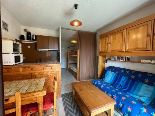 un salon avec un canapé et une table dans l'établissement Mini T2 à Barcelonnette pour 4 avec balcon, TV et coin-cuisine équipé - FR-1-165A-111, à Barcelonnette