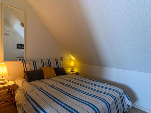 a bedroom with a bed with a striped blanket at Apartment Plein Océan-3 by Interhome in Carnac