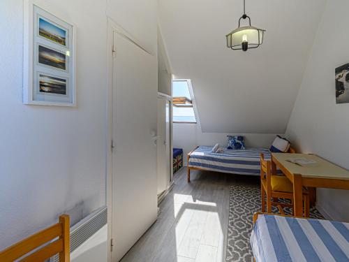 Cette petite chambre comprend une table et un lit. dans l'établissement Apartment Plein Océan-3 by Interhome, à Carnac