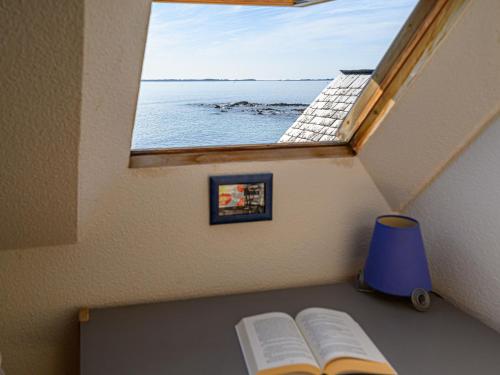 deux livres assis sur une étagère avec une fenêtre dans l'établissement Apartment Plein Océan-2 by Interhome, à Carnac