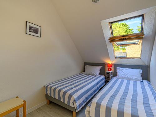 two beds in a small room with a window at Apartment Plein Océan-2 by Interhome in Carnac