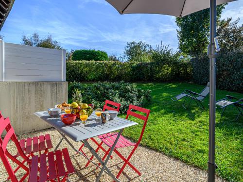 une table avec quatre chaises rouges et un parasol dans l'établissement Apartment Salicornia by Interhome, à Carnac