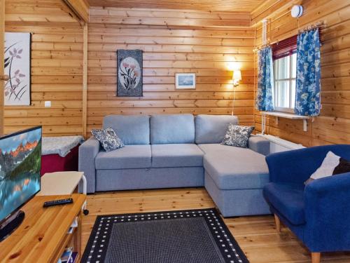 un salon avec un canapé bleu et une télévision dans l'établissement Holiday Home Sotka 13 by bomba by Interhome, à Nurmes