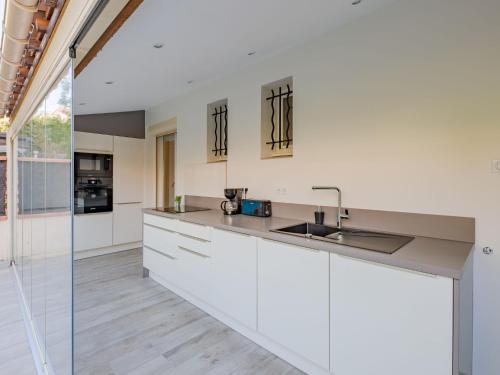 une cuisine avec des armoires blanches et un évier dans l'établissement Apartment Le Mas des Calanques-2 by Interhome, à Saint-Aygulf