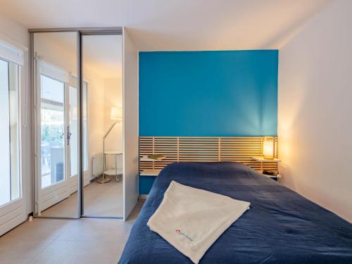 une chambre avec un lit et un mur bleu dans l'établissement Apartment Le Mas des Calanques-2 by Interhome, à Saint-Aygulf