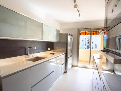 una cocina con armarios blancos y fregadero en Apartment Les Jardins du Luxembourg by Interhome, en Hyères