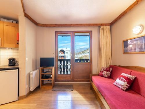 - un salon avec un canapé rouge et une fenêtre dans l'établissement Apartment Le Hameau du Borsat - Val Claret-13 by Interhome, à Tignes