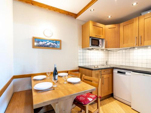 une petite cuisine avec une table et des chaises en bois dans l'établissement Apartment Le Hameau du Borsat - Val Claret-13 by Interhome, à Tignes
