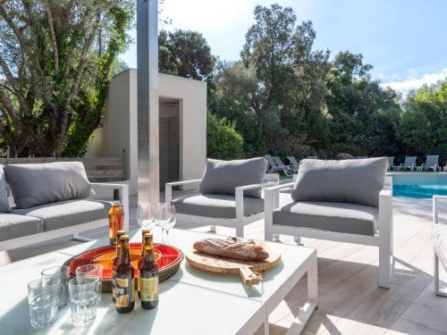 - une table avec des bouteilles de vin sur la terrasse dans l'établissement Villa Villa Romana by Interhome, à Porto-Vecchio