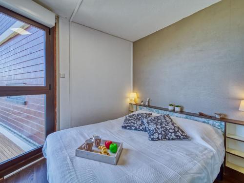 a bedroom with a bed with a tray of fruit on it at Apartment Baikonour-8 by Interhome in Le Corbier