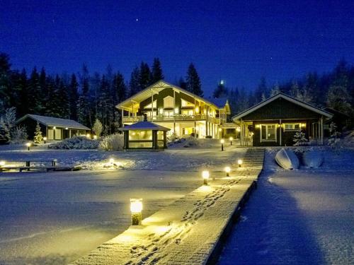 a house with lights in the snow at night at Holiday Home Villa keidas by Interhome in Pertunmaa