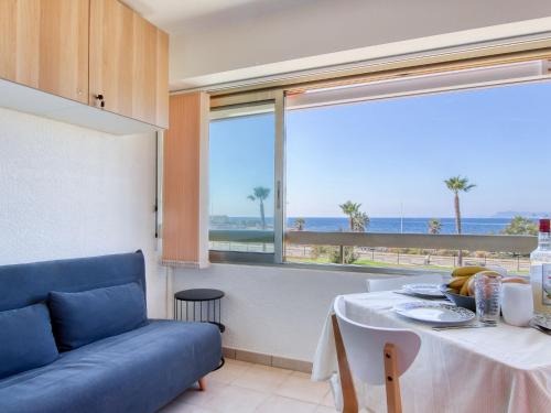 un salon avec une table et un canapé bleu dans l'établissement Apartment Les Marines d'Aryana-4 by Interhome, à Six-Fours-les-Plages