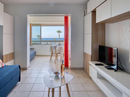 un salon avec un canapé, une télévision et une table dans l'établissement Apartment Les Marines d'Aryana-4 by Interhome, à Six-Fours-les-Plages
