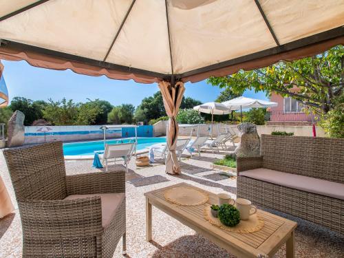 a patio with a table and a large umbrella at Apartment L'Oasi Trilo A6 by Interhome in Trinità dʼAgultu