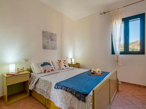 a bedroom with a large bed and a window at Apartment L'Oasi Trilo A6 by Interhome in Trinità dʼAgultu