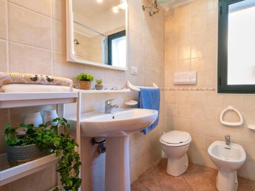 a bathroom with a sink and a toilet and a mirror at Apartment L'Oasi Trilo A6 by Interhome in Trinità dʼAgultu