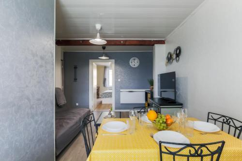 - une salle à manger et un salon avec une table et des chaises jaunes dans l'établissement Le Clem'S - Entre Metz et le Luxembourg, à Amnéville