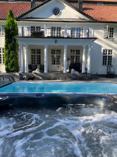 uma piscina em frente a uma casa em Forsså Herrgård hotell och SPA em Näsviken