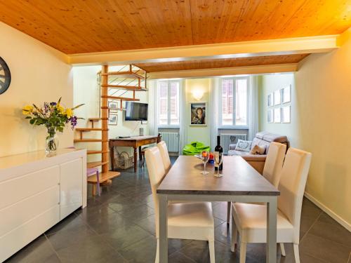 a dining room and living room with a table and chairs at Apartment Baby by Interhome in Bellano
