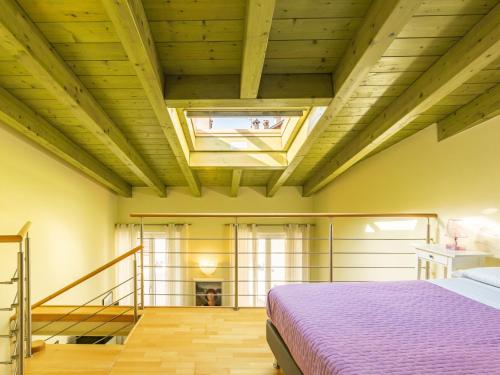 a bedroom with a bed and a wooden ceiling at Apartment Baby by Interhome in Bellano