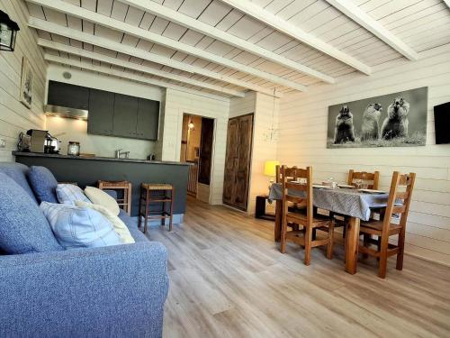 un salon avec un canapé bleu et une table dans l'établissement **Duplex Rénové en Frond de Neige avec Terrasse et Equipements Modernes** - FR-1-165A-179, à Uvernet