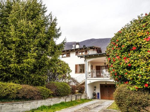 a white house with a balcony and a tree at Apartment Roberto by Interhome in Mergozzo