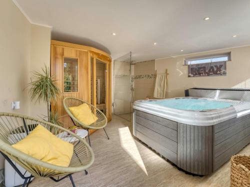 baño grande con bañera de hidromasaje y sillas en Apartment Dubi by Interhome, en Klana