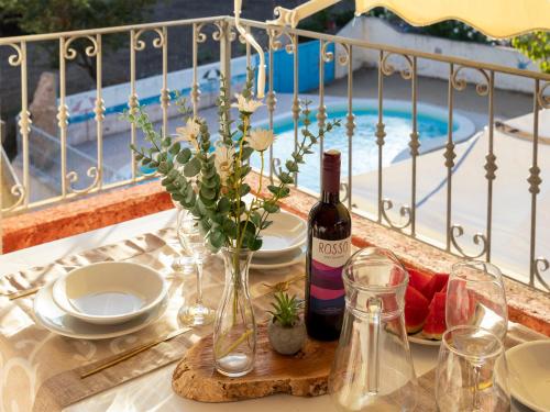 a table with a bottle of wine and glasses on a balcony at Apartment L'Oasi Trilo A5 by Interhome in Trinità dʼAgultu