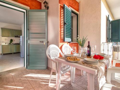 a white table with plates of food on it at Apartment L'Oasi Trilo A5 by Interhome in Trinità dʼAgultu