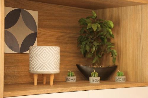 a shelf with potted plants and a chair on it at Ubaia charme & conforto in Pipa