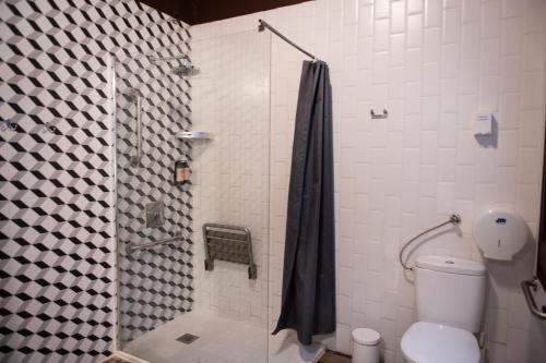 a bathroom with a shower with a toilet and a shower curtain at The Loft House Barcelona in Barcelona