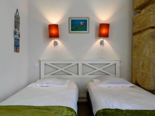 2 camas en una habitación con 2 luces en la pared en Apartment Le Château de Kergonano-3 by Interhome, en Baden