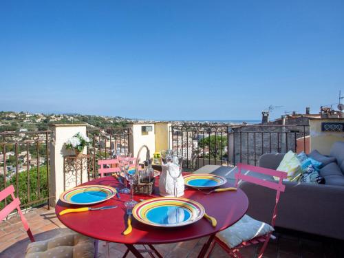 una mesa roja con platos en la parte superior de un balcón en Apartment Doux Bijou by Interhome, en Cagnes-sur-Mer