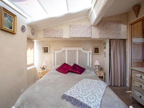 une chambre avec un grand lit avec des oreillers rouges dans l'établissement Apartment Doux Bijou by Interhome, à Cagnes-sur-Mer