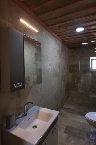 a bathroom with a sink and a mirror at Stone Owl Otel & Restaurant in Uchisar