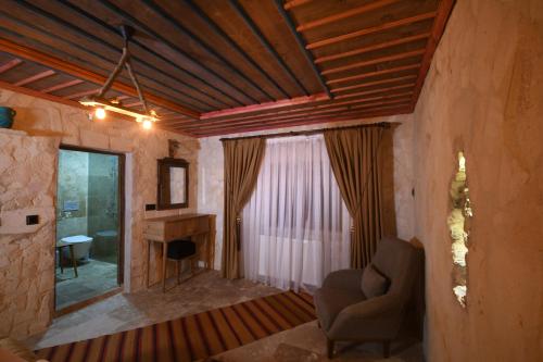 ein Wohnzimmer mit einem Stuhl und einem Schreibtisch in der Unterkunft Stone Owl Otel & Restaurant in Uchisar