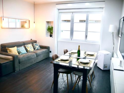 un salon avec une table et un canapé dans l'établissement L'Emeraude - Paris 19ème Arrondissement, à Paris