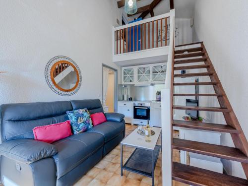 - un salon avec un canapé bleu et un escalier en colimaçon dans l'établissement Apartment Les Bastides de Grand Stade-12 by Interhome, à Saint Cyprien Plage