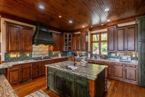 a large kitchen with wooden cabinets and a large island at Overlook Estate in The Farm in Banner Elk