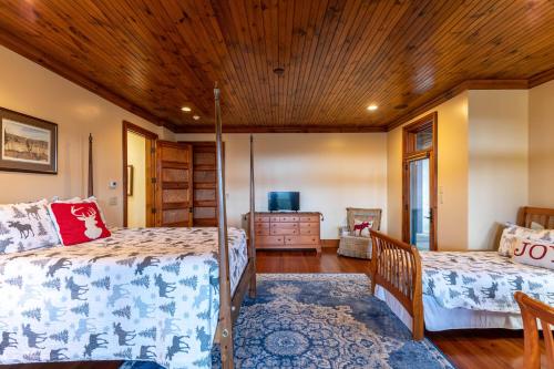 a bedroom with two beds and a wooden ceiling at Overlook Estate in The Farm in Banner Elk