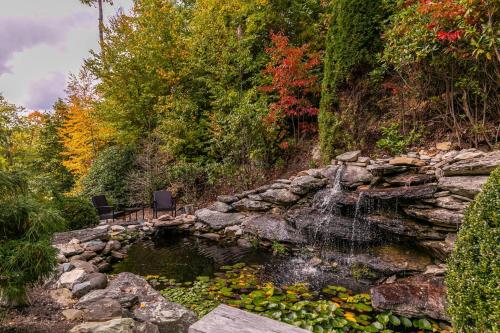 a bench sitting next to a pond with a waterfall at Overlook Estate in The Farm in Banner Elk