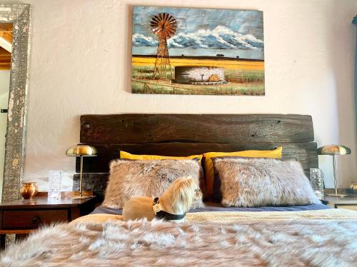 a dog sitting on a bed in a bedroom at Critchely Stone Villa, Dullstroom in Dullstroom