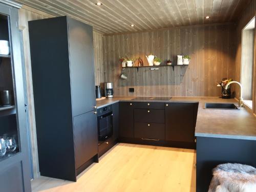 cocina con armarios negros y encimera en Holiday Home Sinnsro - VDS100 by Interhome en Ron