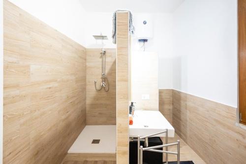 ein Badezimmer mit einem weißen Waschbecken und Holzwänden in der Unterkunft Piazza Laurino Apartments in Laurino