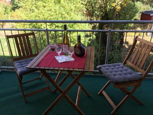 - une table en bois avec 2 chaises et des verres à vin dans l'établissement Ferienhaus "Am Saarbach", à Ochsenfurt