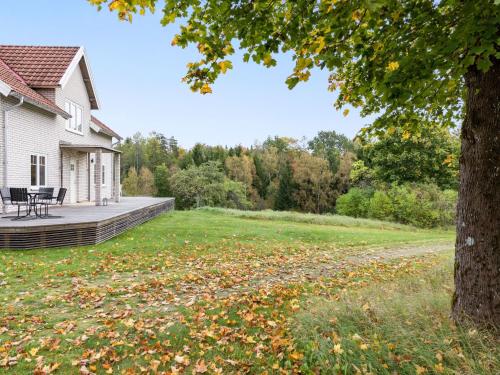 a house with a yard with leaves on the grass at Holiday Home Älmegården by Interhome in Lammhult