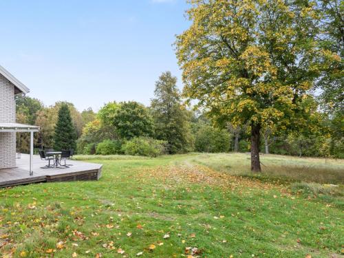 a picnic table on a deck next to a tree at Holiday Home Älmegården by Interhome in Lammhult