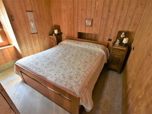 a bedroom with a bed and a wooden wall at Apartment La Casetta di Biorca by Interhome in Tartano