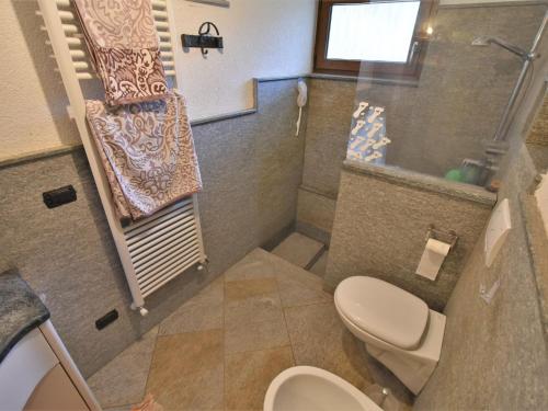 a small bathroom with a toilet and a sink at Apartment La Casetta di Biorca by Interhome in Tartano