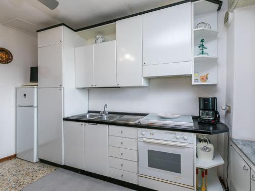 a white kitchen with a sink and a refrigerator at Apartment La casa del Fale di Collodi by Interhome in Collodi